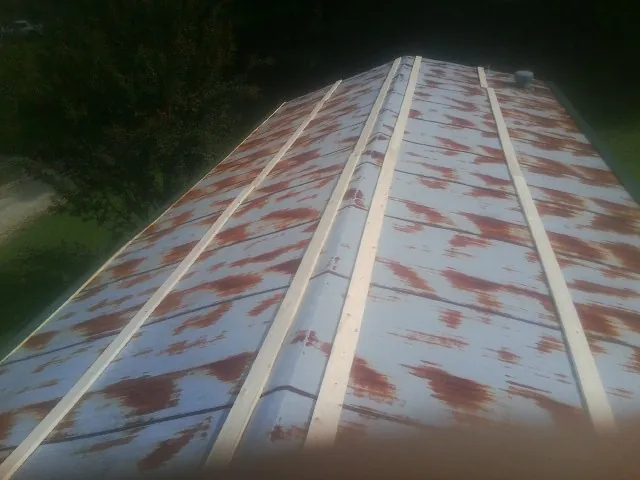 Rusted metal roof panels with new wood purlins before replacement — Storm Damage Roof Repair in Mill Creek by Roofing Brothers
