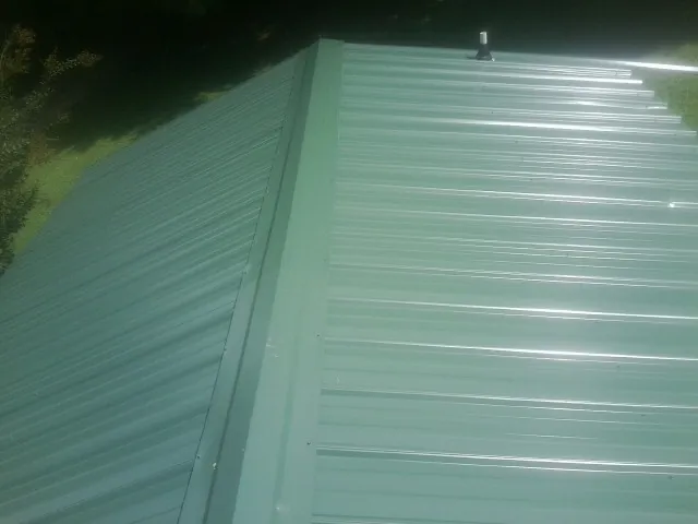 New green metal panels meeting at the ridge of a roof in Mill Creek